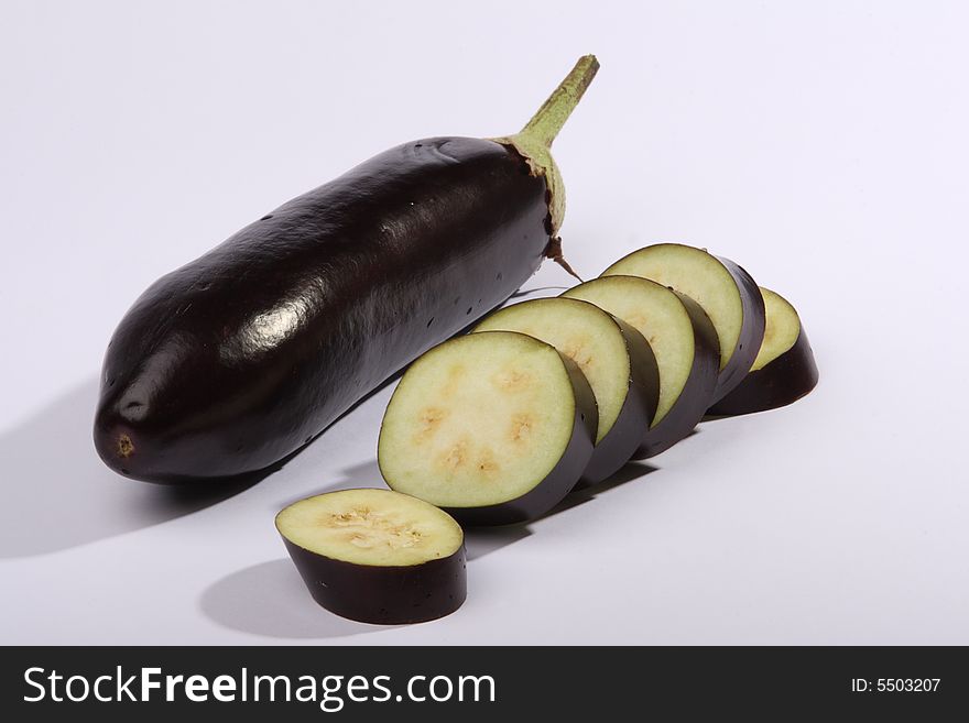 The whole and pieces of an eggplant on a white background