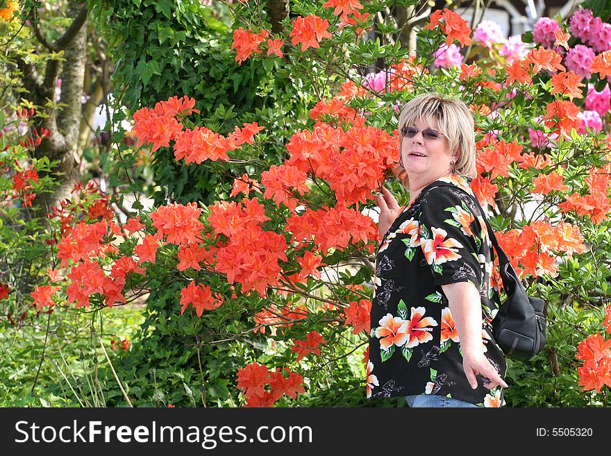 Woman in floral shirt posing cutely with flowers. Woman in floral shirt posing cutely with flowers