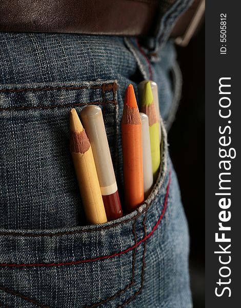 Colored pencils coming out from a jeans pocket.