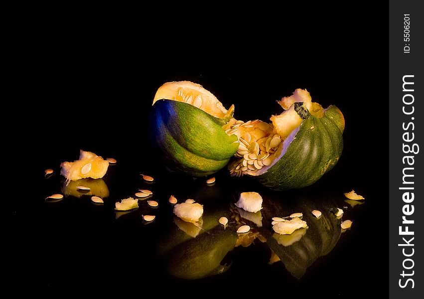 Smashed acorn squash broken open, isolated over black. Smashed acorn squash broken open, isolated over black
