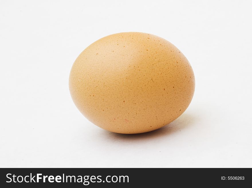 Speckled egg laying down against white background