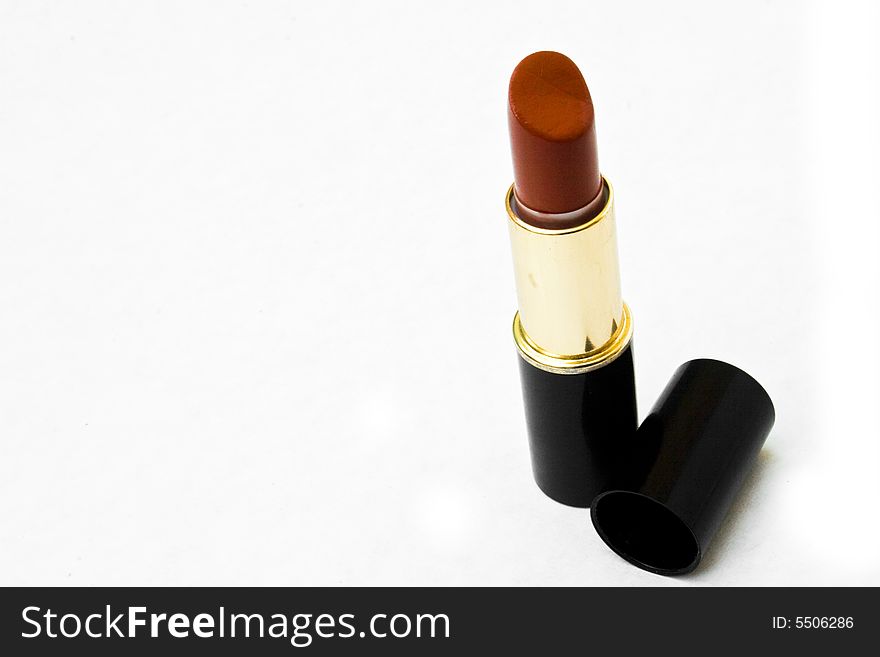 Lipstick standing on end with cap next to it. Lipstick standing on end with cap next to it