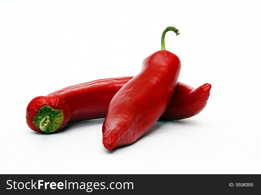 Hot red chili peppers on white background one laying on the other