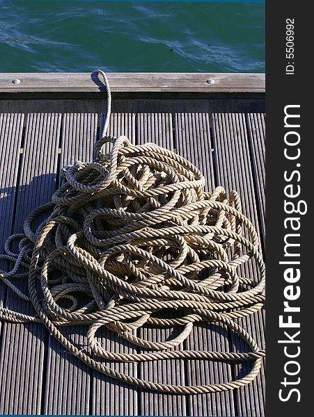 Pile of Coiled Rope on Dock by Water. Pile of Coiled Rope on Dock by Water