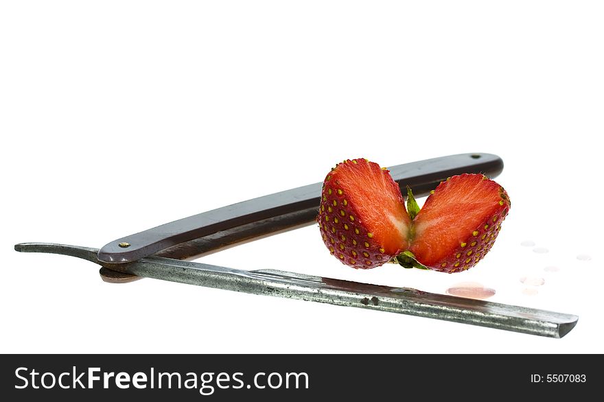 Strawberry and straight razor isolated on the white background