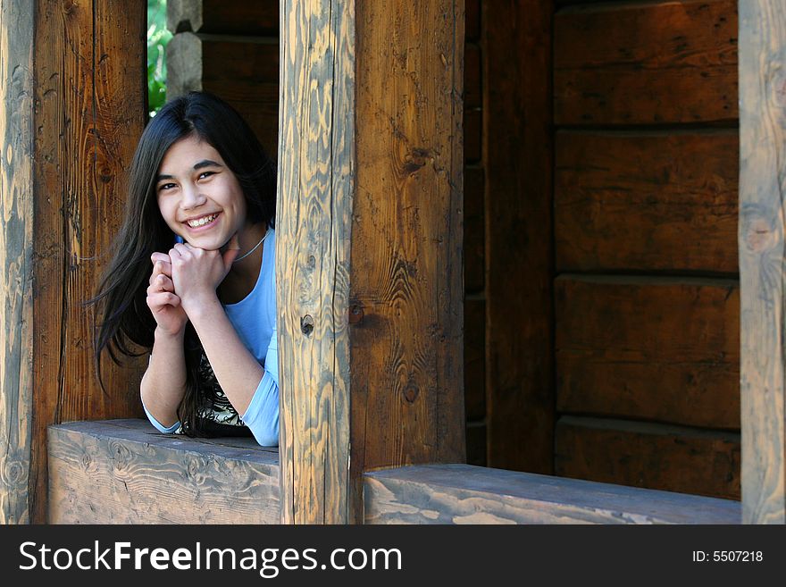 Beautiful young teen girl relaxing on porch, part asian, scandinavian background. Beautiful young teen girl relaxing on porch, part asian, scandinavian background