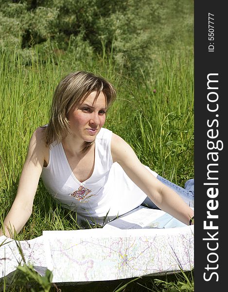 Beautiful girl looks at the map on nature. Beautiful girl looks at the map on nature