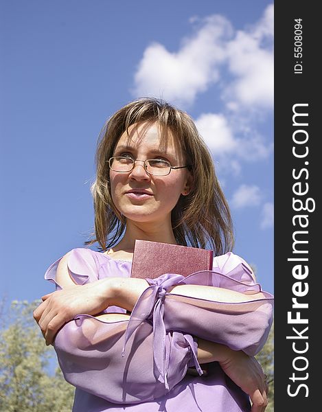 Smiling woman in lilac holding a book. Smiling woman in lilac holding a book