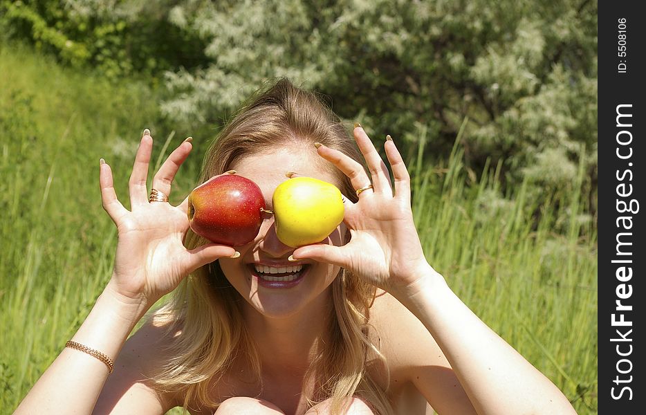 A young cute woman holding up two apples