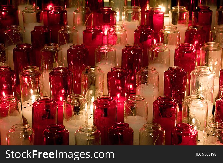 Candles in color glasses in a church. Candles in color glasses in a church