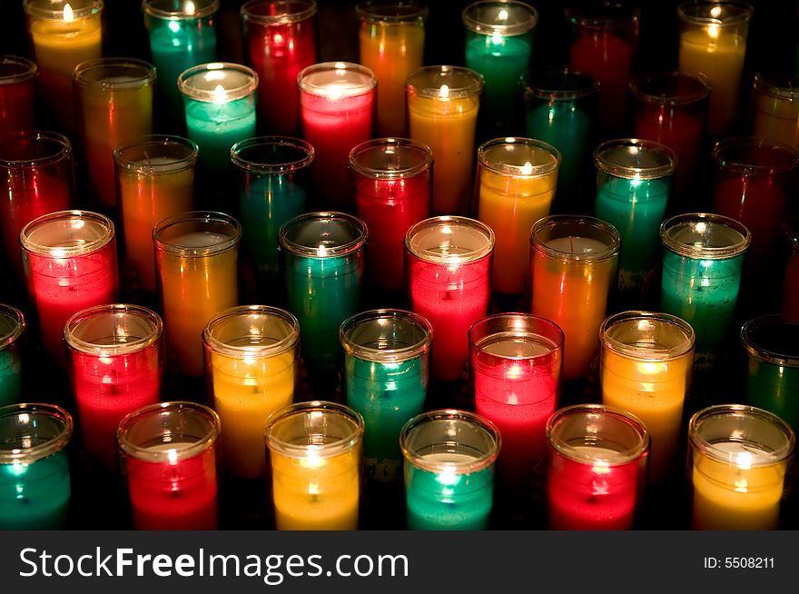 Candles in color glasses in a church. Candles in color glasses in a church