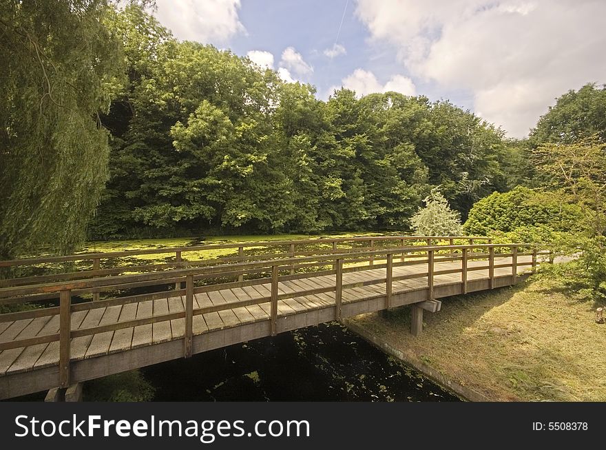 Wooden bridge in a park next to a dutch canal