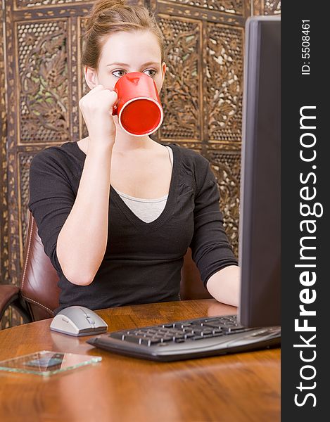 Female executive working on a PC keyboard and/or mouse on a wooden desk. Female executive working on a PC keyboard and/or mouse on a wooden desk.