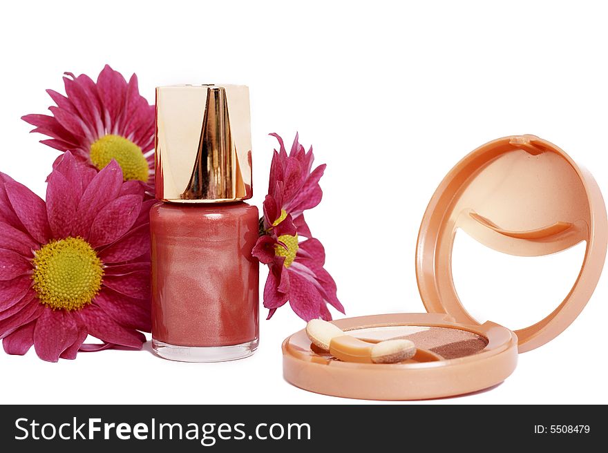 Fashionable dark pink nail polish with daisy flowers and golden eyeshadow set isolated on white background. Fashionable dark pink nail polish with daisy flowers and golden eyeshadow set isolated on white background