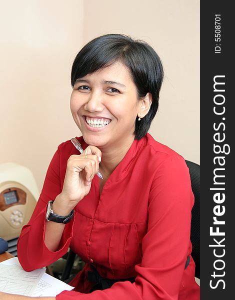 Business woman in red suit smiling at office. Business woman in red suit smiling at office