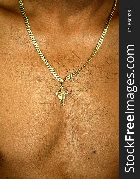 A crucifix hung on a chain on his chest. A crucifix hung on a chain on his chest