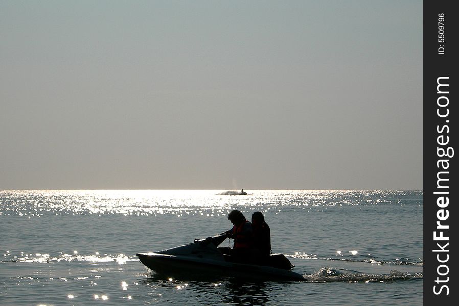 Couple haviing fun on waves with jet-ski under sunset. Couple haviing fun on waves with jet-ski under sunset