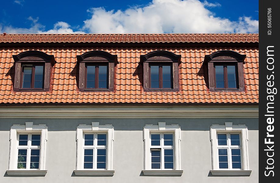 Eight windows of the old building. four are located in the tiled roof. Eight windows of the old building. four are located in the tiled roof