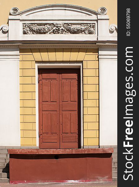 Retro front door decorated with bas-reliefs on sunny day, detail