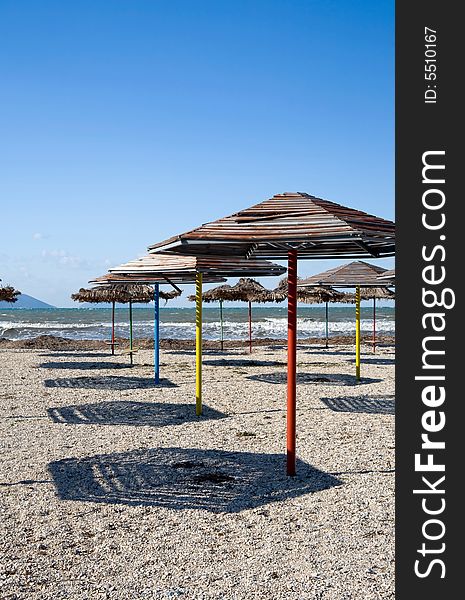 Set of beach umbrellas on sand making shadows under the blue clear sky in hot day. Set of beach umbrellas on sand making shadows under the blue clear sky in hot day
