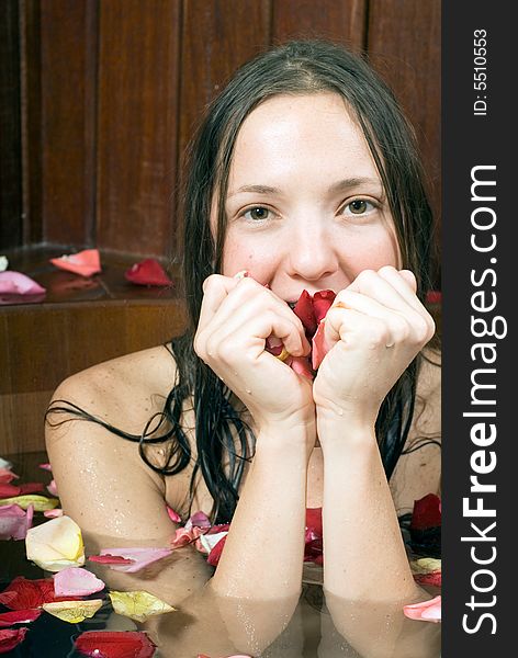 An attractive young lady submerged in water, surrounded by multi-colored roses. Vertically framed shot. An attractive young lady submerged in water, surrounded by multi-colored roses. Vertically framed shot.