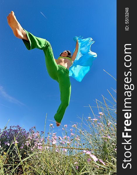 Girl with blue silk scarf jumping and the blue sky