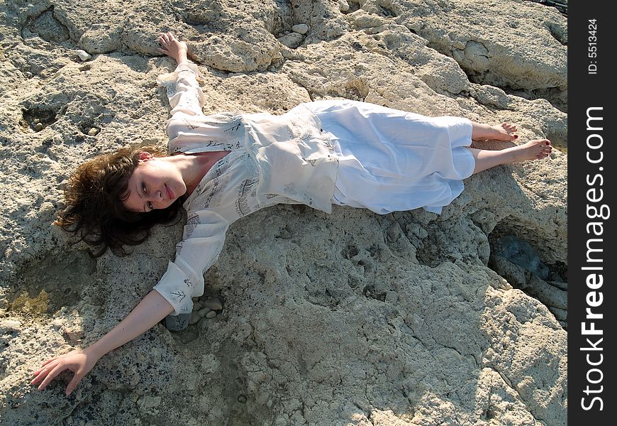 Young beautiful barefoot lady on stone beach smiling. Young beautiful barefoot lady on stone beach smiling