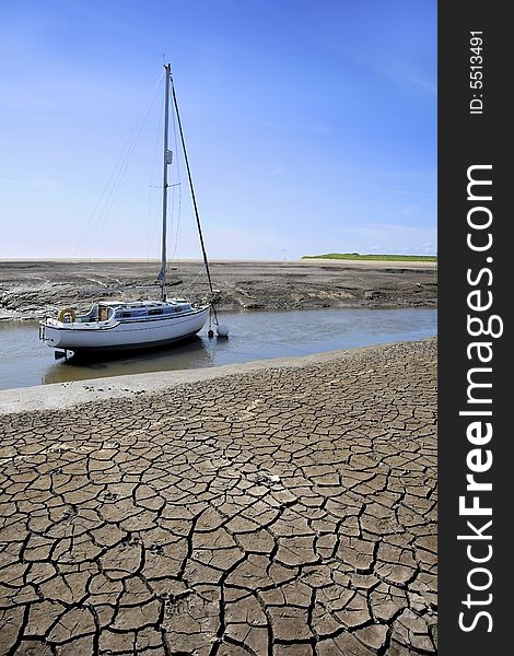 Sailing boat or yacht moored in river during period of dry weather