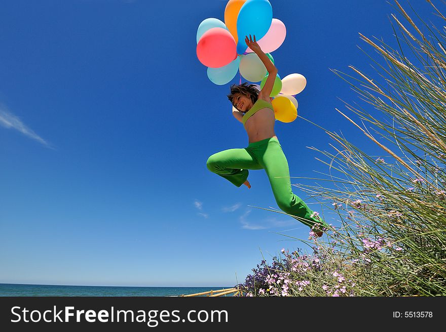 Girl with colorful balloons jumping on the beach. Girl with colorful balloons jumping on the beach