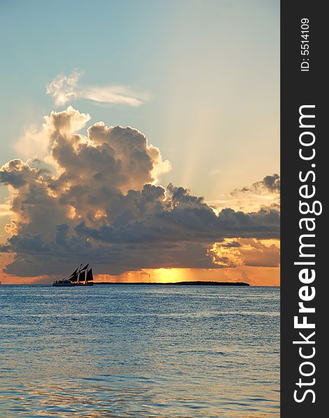 A sailing ship in front of scenic Clouds covering the sun