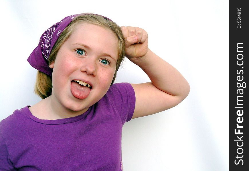 A little girl dressed all in purple is pounding her head and making a funny face. A little girl dressed all in purple is pounding her head and making a funny face