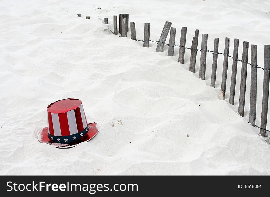 Stars and stripes on a hat in the sand. Stars and stripes on a hat in the sand.