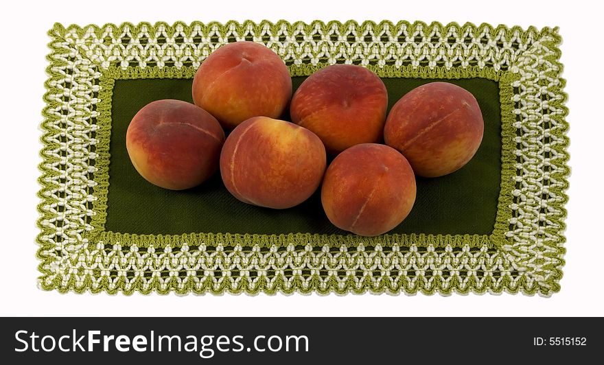 Ripe peaches on the patterned green serviette