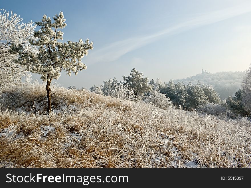 Sunny winter landscape with tree and monastery on mountain in background. Sunny winter landscape with tree and monastery on mountain in background.