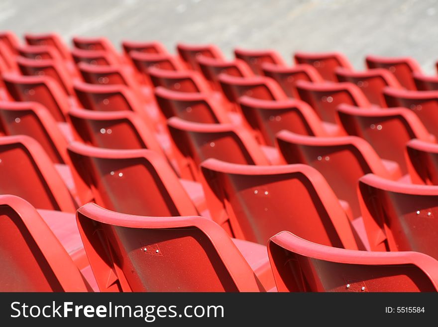 Empty red chairs in open-air arena