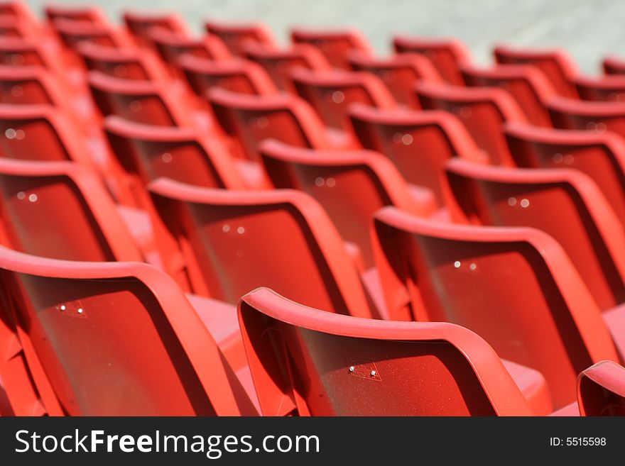 Empty red chairs in open-air arena