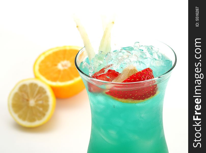 Tropical Acoholic Drink Made of Rum, Pineapple Juice, Blue Curacao, Sweet and Sour Mix. Slice of Apple and Strawberry as a Garnish. Tropical Acoholic Drink Made of Rum, Pineapple Juice, Blue Curacao, Sweet and Sour Mix. Slice of Apple and Strawberry as a Garnish.