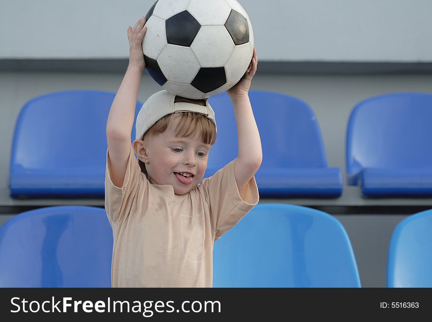 The boy with a ball on tribunes of stadium