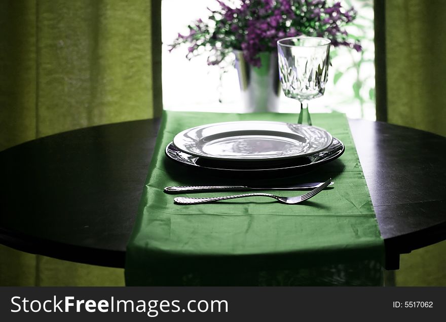 An elegant restaurant table setting in green. An elegant restaurant table setting in green