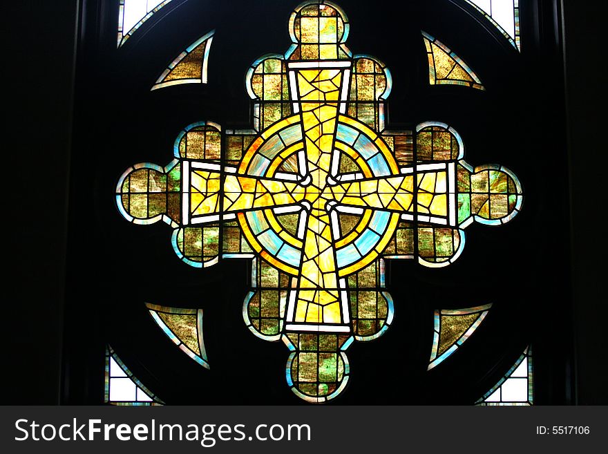 Stained glass window in the shape of a cross found in a church