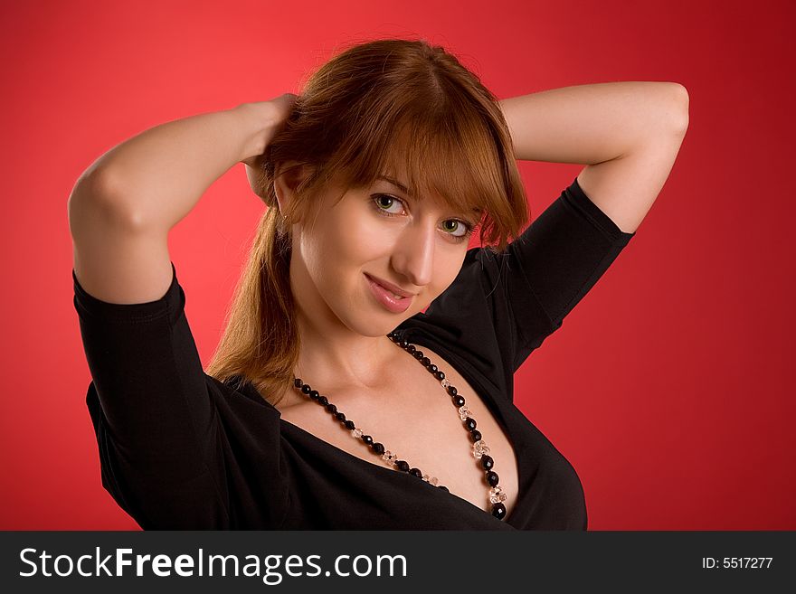 Attractive girl in evening dress isolated on red background