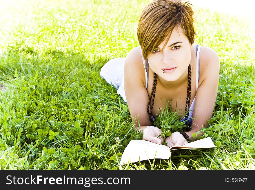 Beautiful blond woman reading over the grass. Beautiful blond woman reading over the grass.