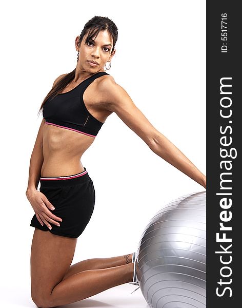 Beautiful brunette woman exercising with a gray yoga ball