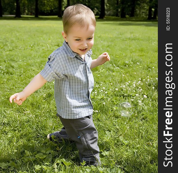 The Kid Running On A Green Meadow. The Kid Running On A Green Meadow