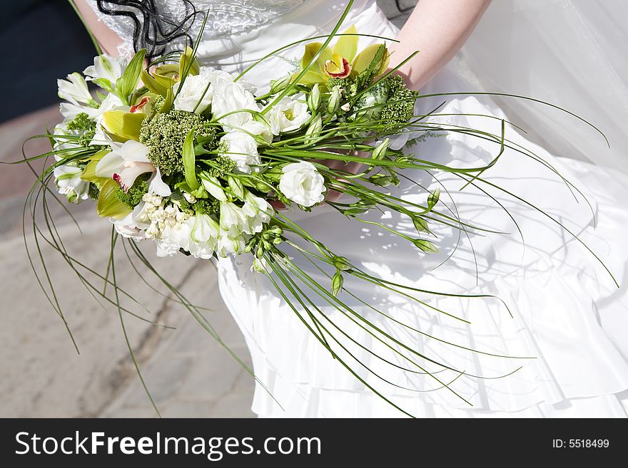 Bouquet with orchids in the hands of the bride. Bouquet with orchids in the hands of the bride