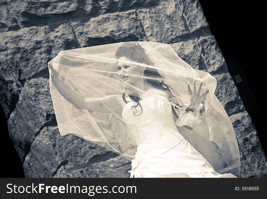 Bride near the stone wall in black and white. Bride near the stone wall in black and white