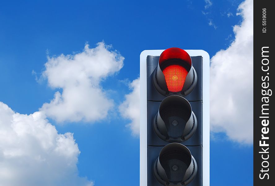 Red traffic light against cloudy blue sky. Red traffic light against cloudy blue sky