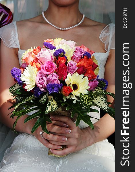 Close-up of a bride holding a wedding bouquet.