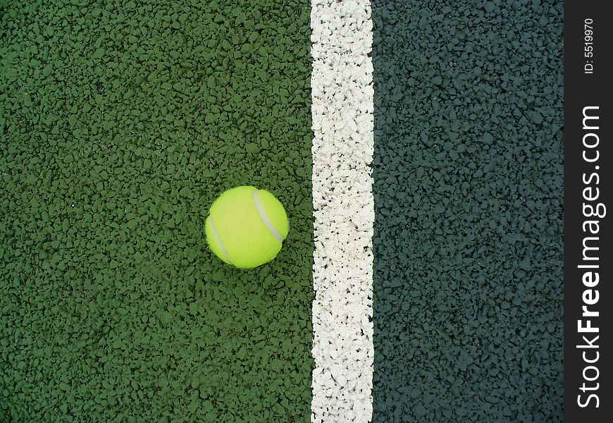 Yellow tennis ball in play on a tennis court. Yellow tennis ball in play on a tennis court