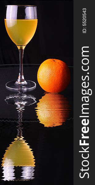 Fruit juice in glass, apple, orange and reflection